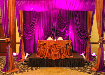 Colorful drapery creates an intimate space. Image provided by The Finishing Touch Wedding Design