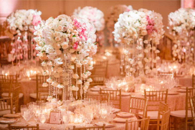 Orchids and roses are softly lit by abundant candles. Image provided by Whit Lilac Event Design Photography by Kristi Klemens Photography
